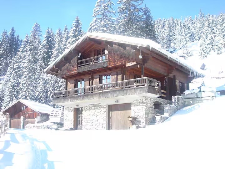 Le chalet de Manigod sous la neige, entouré de sapins
