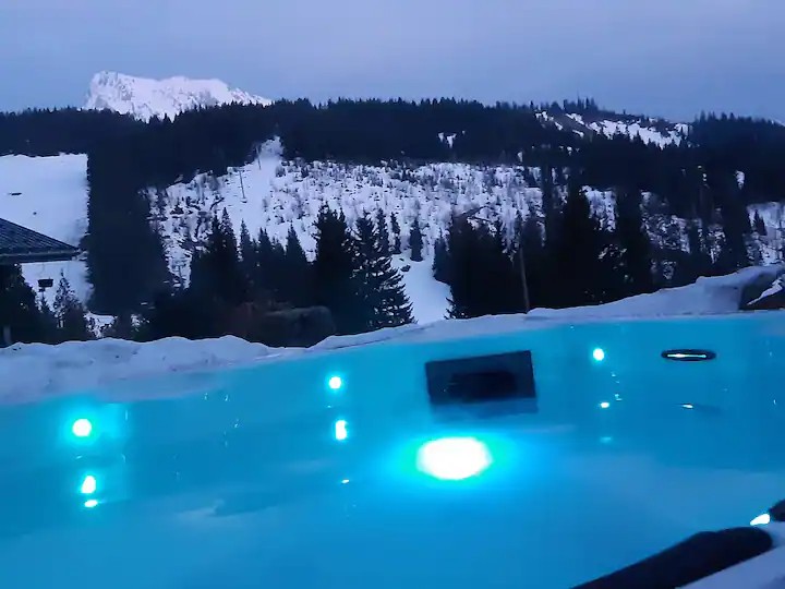 Le jacuzzi au crépuscule face aux montagnes enneigées