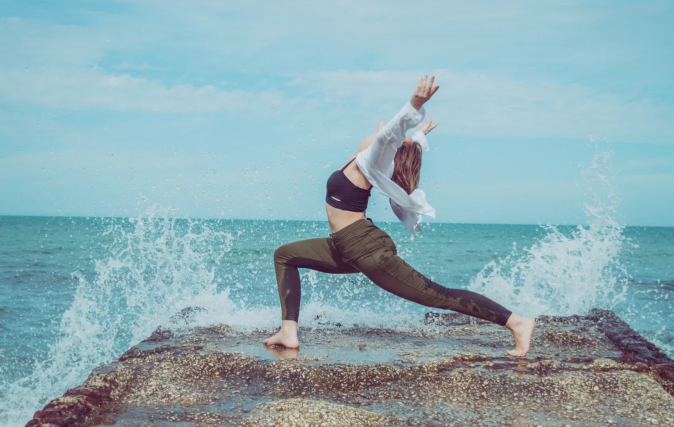Pratique de yoga sur un rocher face aux vagues de l’océan